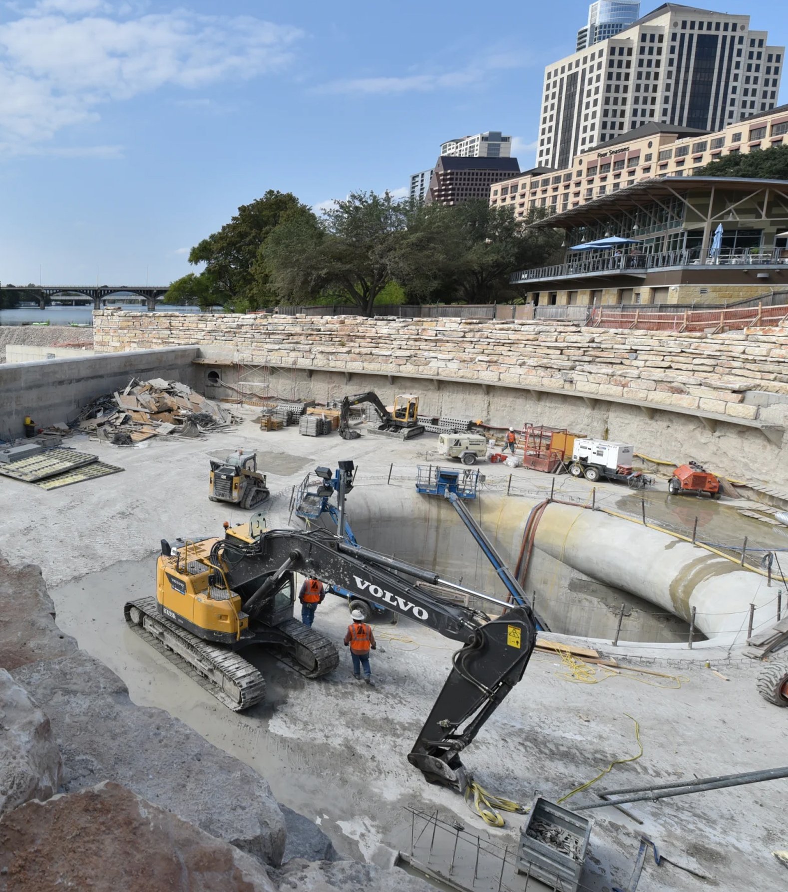 Construction crews and excavator working on a large concrete water infrastructure project