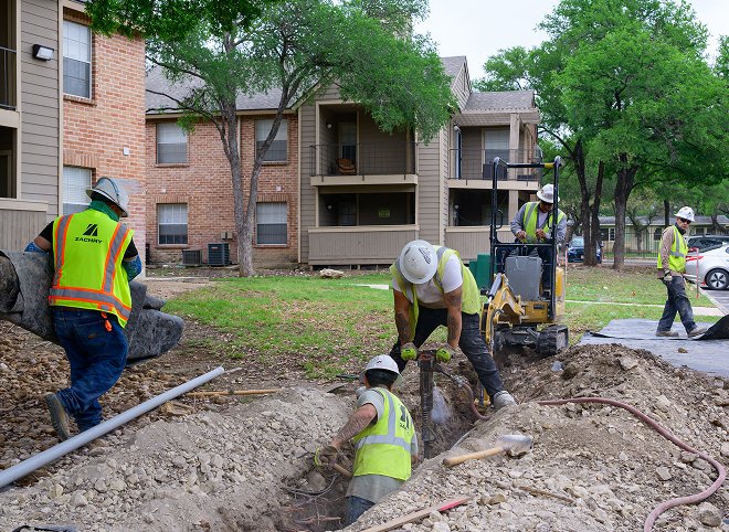 Zachry Underground and Utility Services construction crews installing underground utilities at a residential property