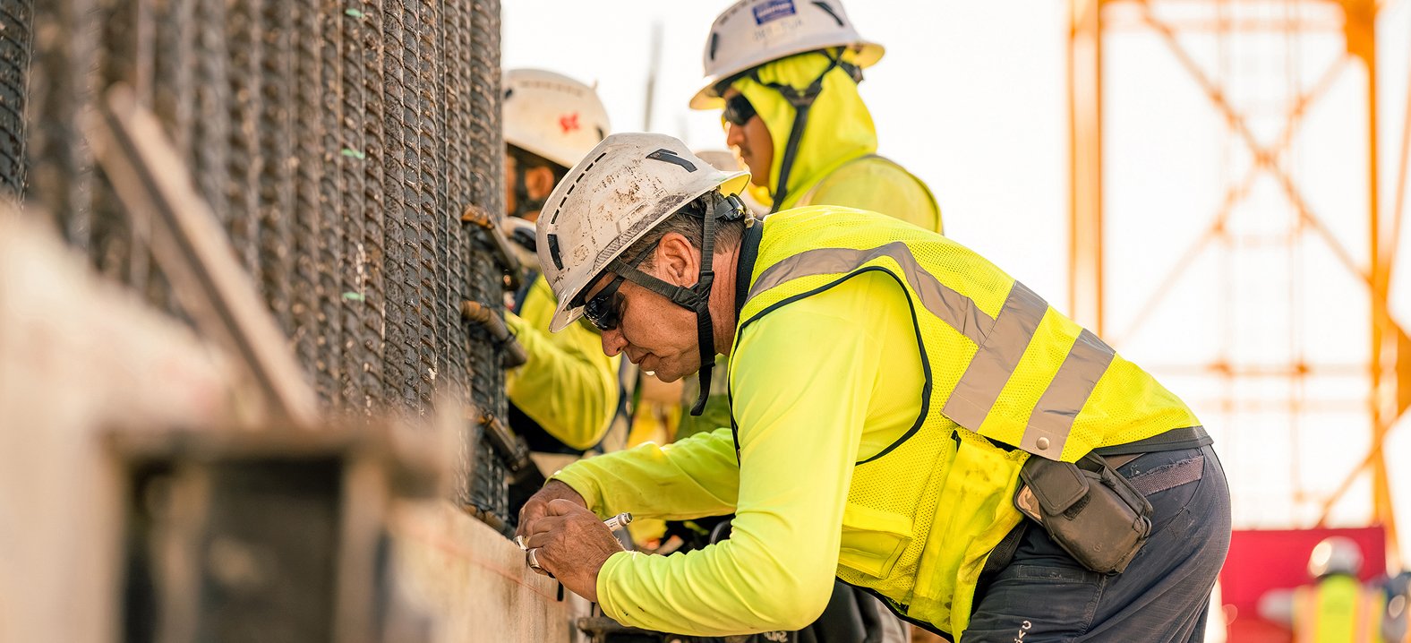 Construction worker marking measurements on a concrete structure