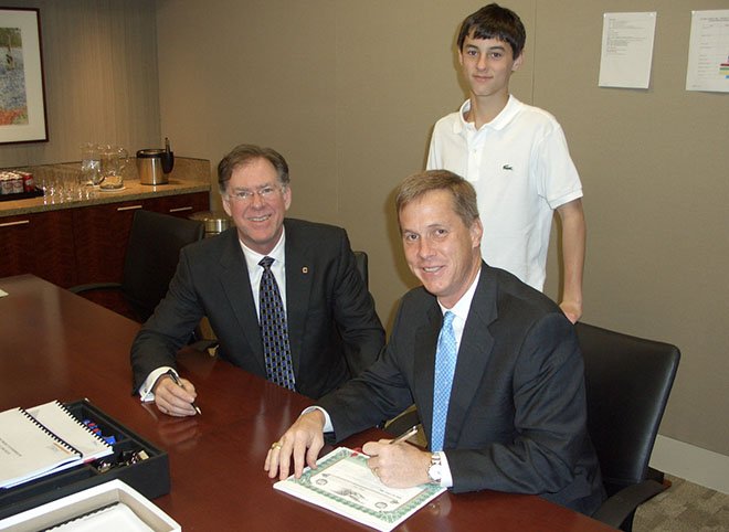 David Zachry signs documents at a conference table during Zachry&rsquo;s 2008 company reorganization