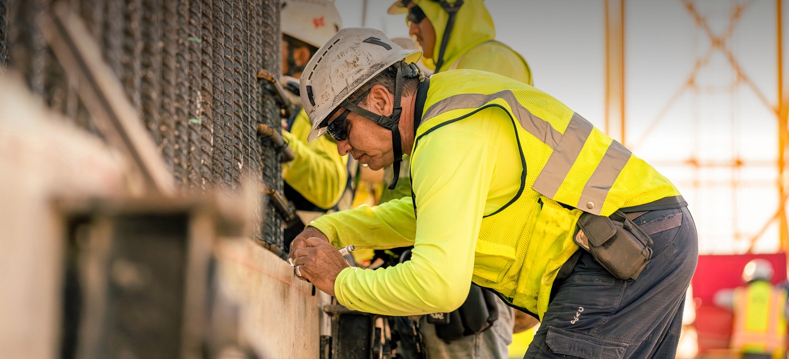 Construction worker marking measurements on a concrete structure