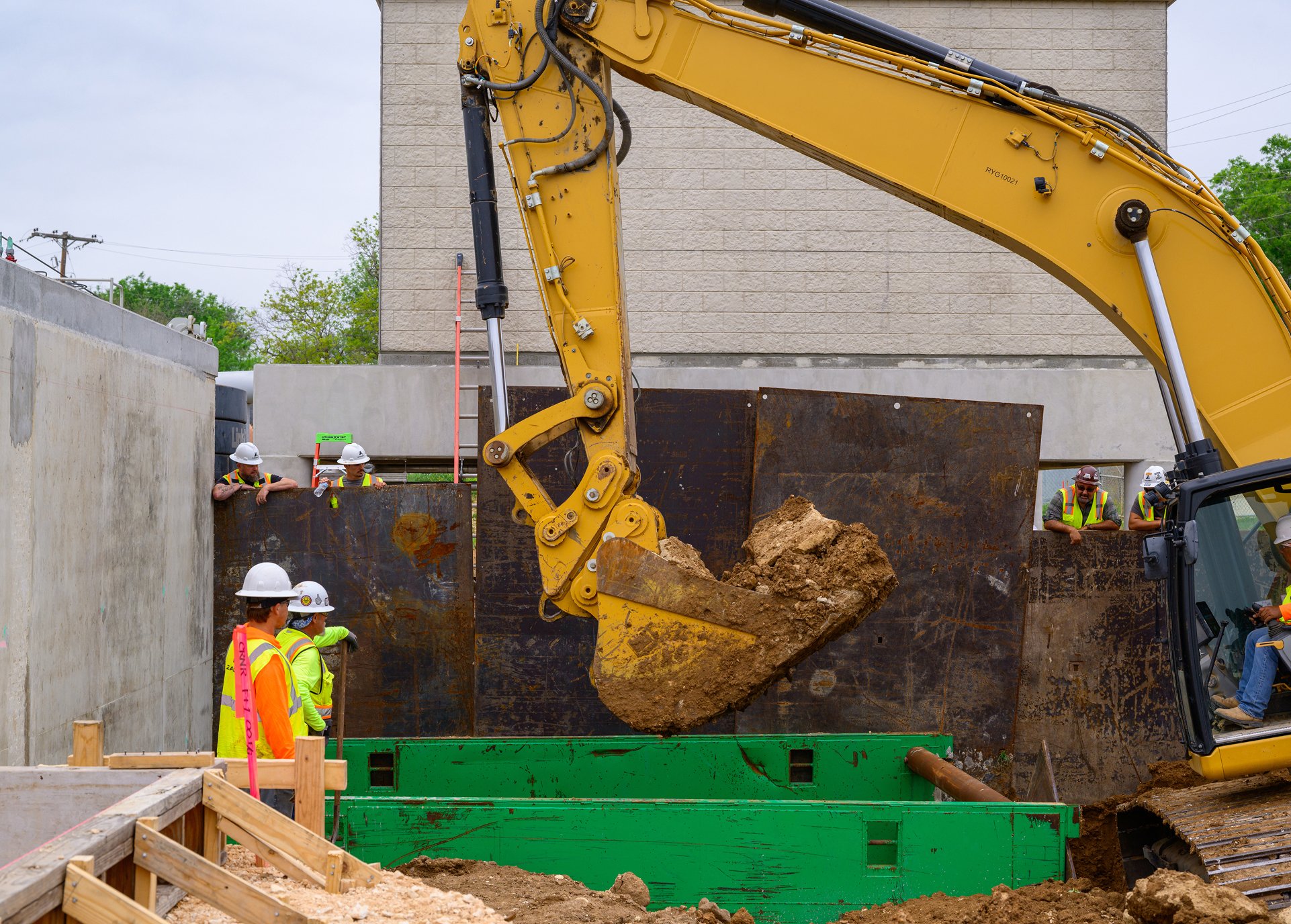 Construction crew working with an excavator on an underground utility project